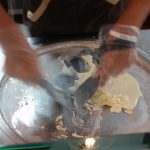 Scrambling the cream on a frozen griddle at Freezing Moo